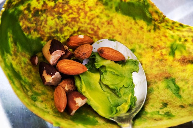 Spoon with almonds chestnuts and avocado pulp