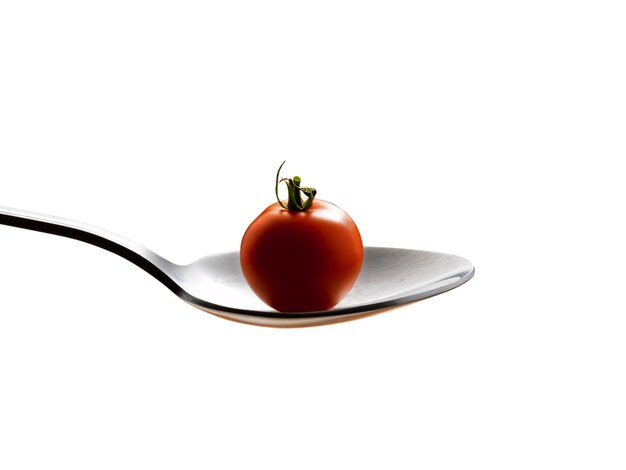 spoon with  cherry tomato on a white background