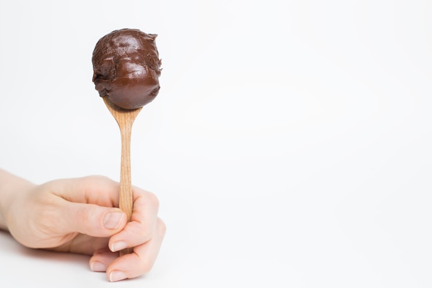 Spoon with chocolate cream on a white background. 