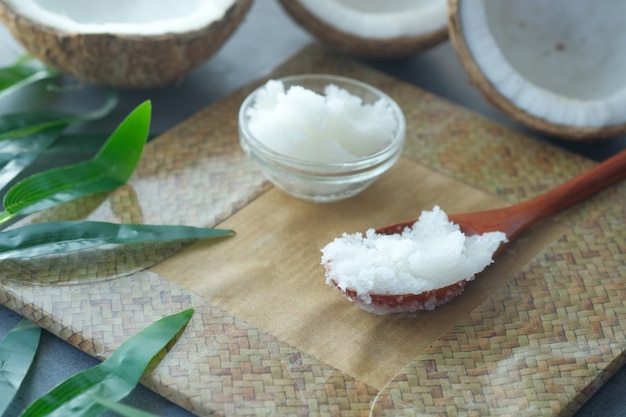 Spoon with coconut oil and nut on black background