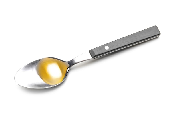 Spoon with cooking oil on white background