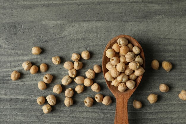 Spoon with fresh chickpea on gray textured wall