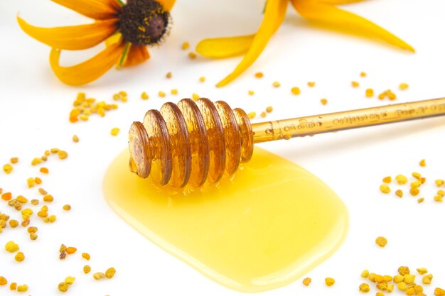 spoon with fresh honey and pollen spilled on a white background. organic vitamin food