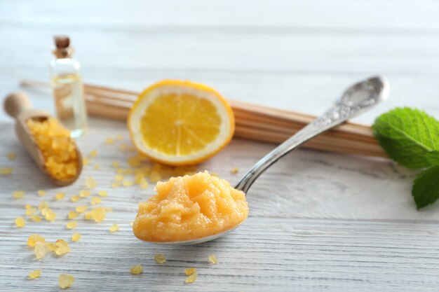 Cucchiaio con macchia d'arancia, sale marino e foglia di menta sul tavolo di legno