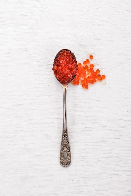 Spoon with red caviar on a wooden background Top view Free space for text