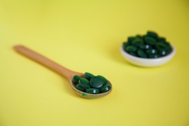 Photo spoon with supplements on a yellow background