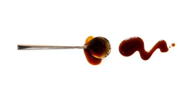 Spoon with teriyaki sauce isolated on white background