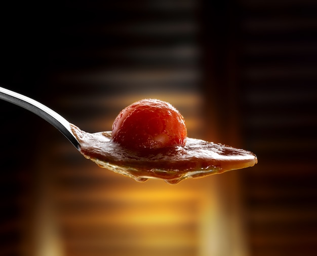 spoon with tomato sauce and cherry tomato