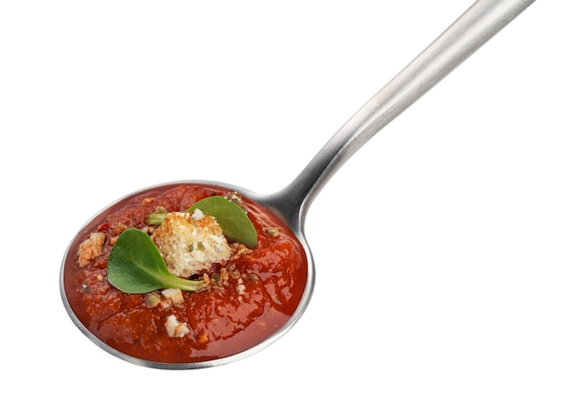 Spoon with tomato soup isolated on white background