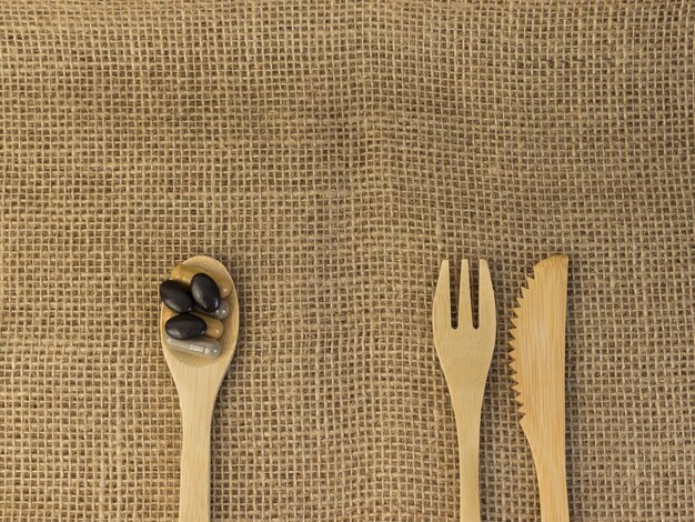 Spoon with vitamins knife and fork on the table