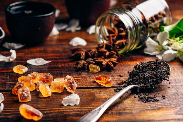 Spoonful of Tea, Apple Flowers, Sugar and Scattered Anise Star on Wooden Table.