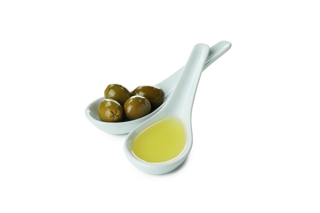 Spoons with olive oil and olives isolated on white surface