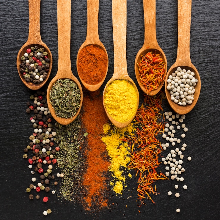 Photo spoons with spices powder and spread on table