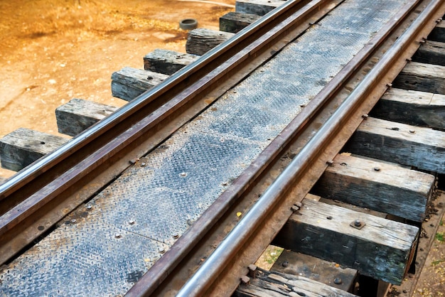 Foto spoor met houten dwarsliggers en roestige rails bij oude spoorbrug