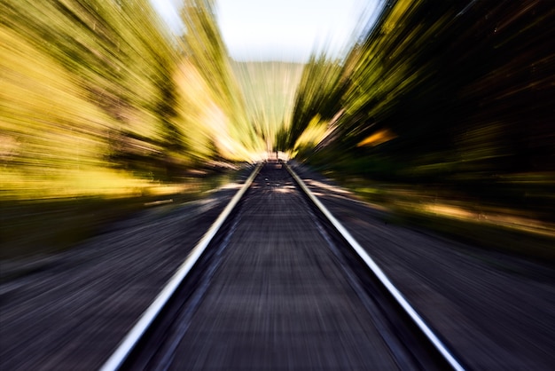 Foto spoorlijn met bewegingsonscherpte - spoorweg die door de abstracte natuur leidt