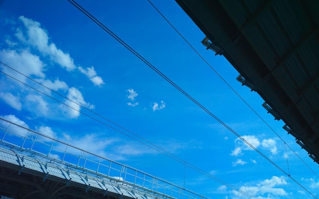 Spoorlijnen hoogspanningslijnen op blauwe hemelachtergrond