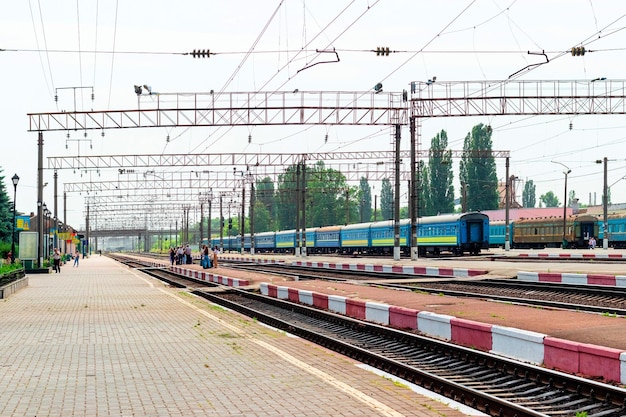 Spoortreinen met rijtuigen en mensen op het perron van het treinstation