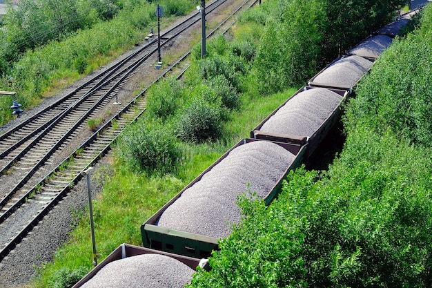 Spoorvrachtwagens geladen met kolen. Goederentrein vervoer van kolen, hout, brandstof. Bovenaanzicht.