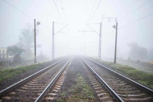 Spoorweg in de mist gaat in het perspectief van de verte