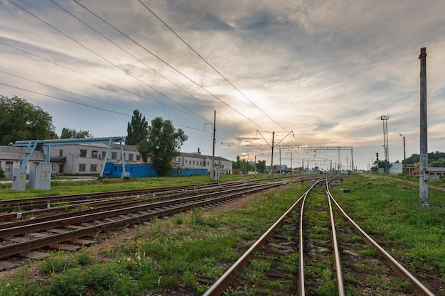 Spoorwegen tegen mooie hemel bij zonsondergang. Industrieel landschap met spoorwegknooppunt. Zware industrie