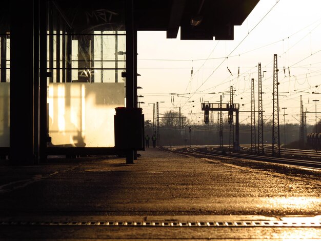 Foto spoorwegplatform bij rails bij zonsondergang