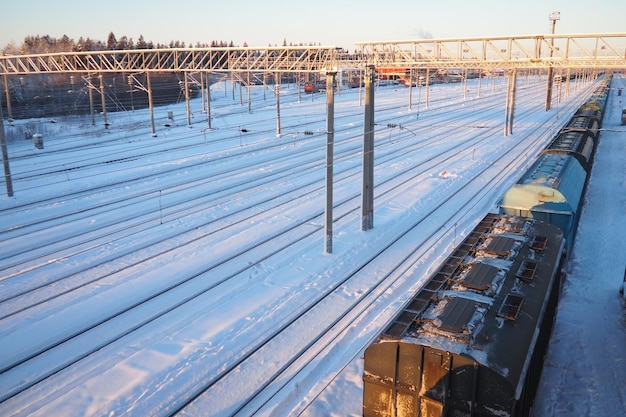 Foto spoorwegstation passagiers- en goederentreinen op rails winter korte pooldag sneeuw en sneeuwstroom