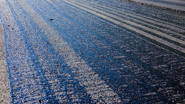 Sporen van bitumen op de stoep