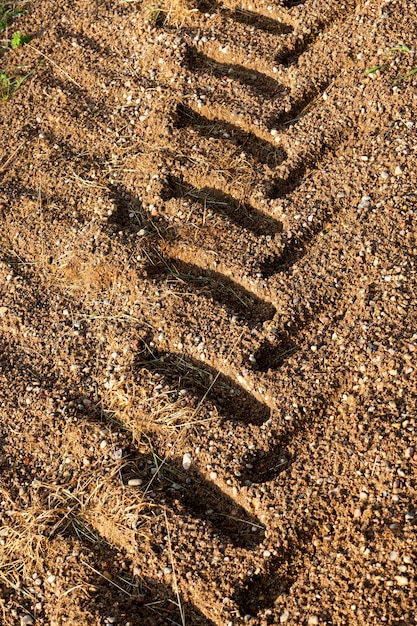 Sporen van tractor- of vrachtwagenwielen op het zand na regen