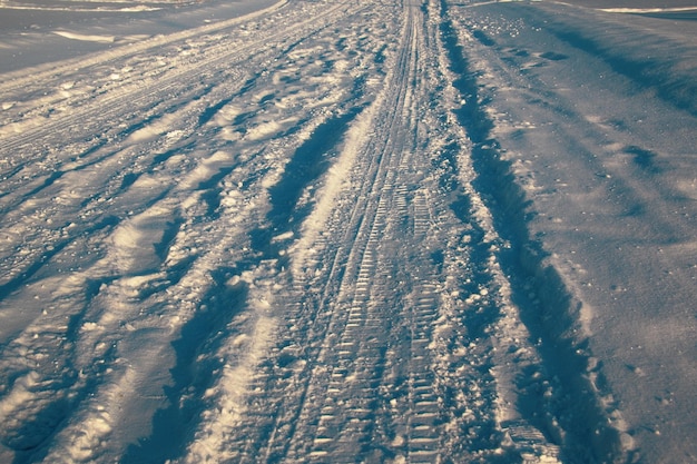 Sporen van voertuigen en mensen op de besneeuwde winterweg