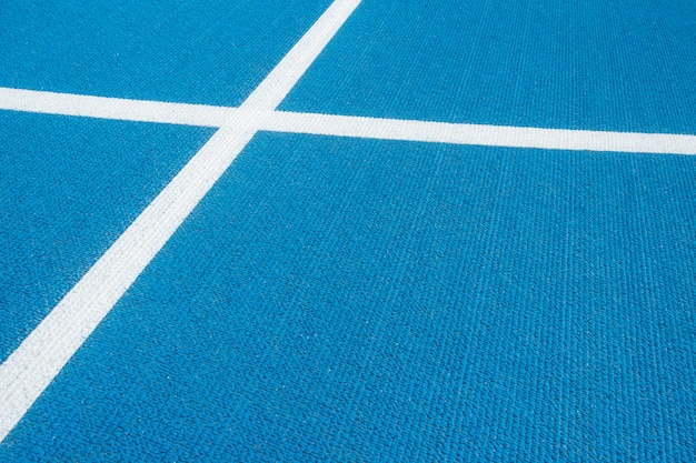 Sport achtergrond. Blauwe renbaan met witte lijnen in sportstadion. Bovenaanzicht