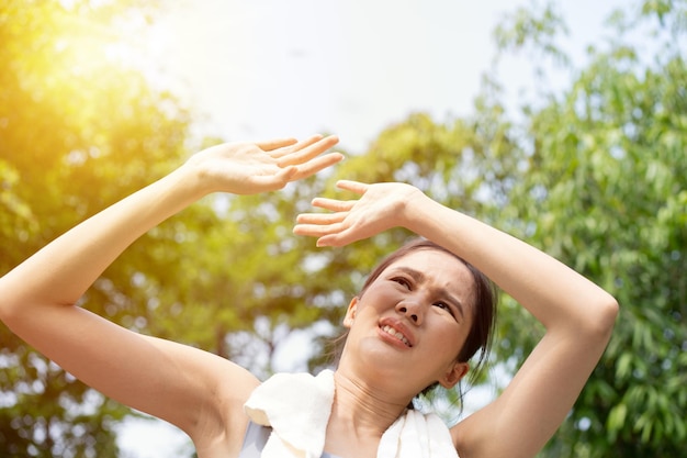 Photo sport asian woman gets tired and get dizzy feel bad pain and suffer from heat stroke outdoors