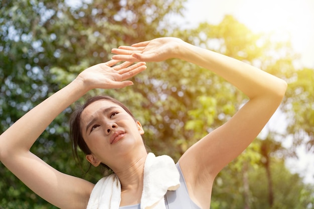 Photo sport asian woman gets tired and get dizzy feel bad pain and suffer from heat stroke outdoors