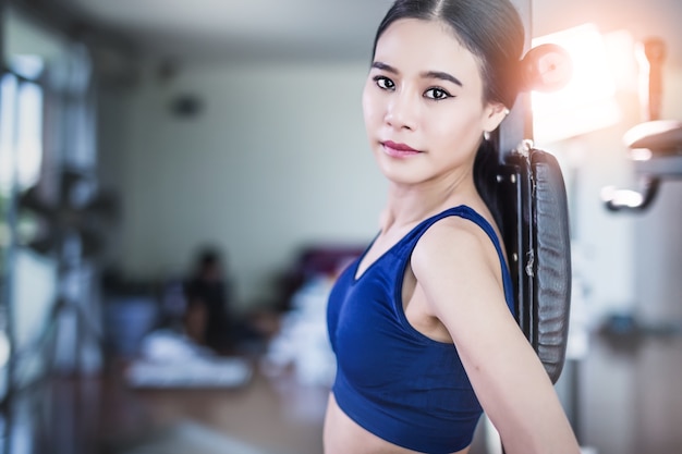 sport asian woman in workout costume  in action with blur fitness background