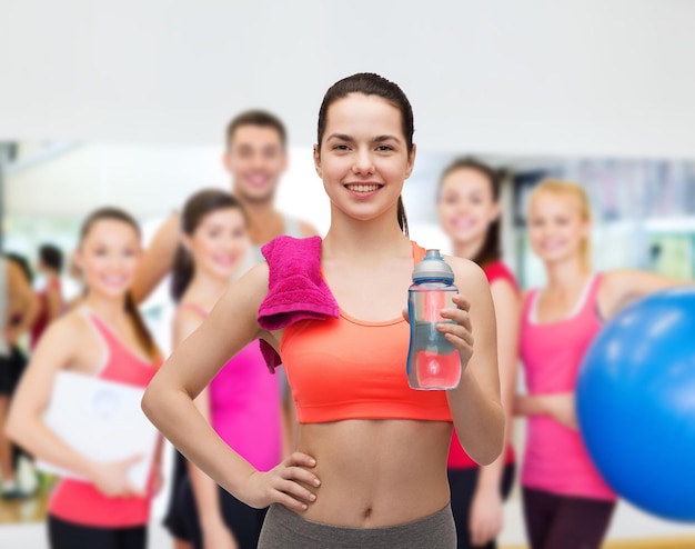 sport, beweging en gezondheidszorg - sportieve vrouw met roze handdoek en waterfles