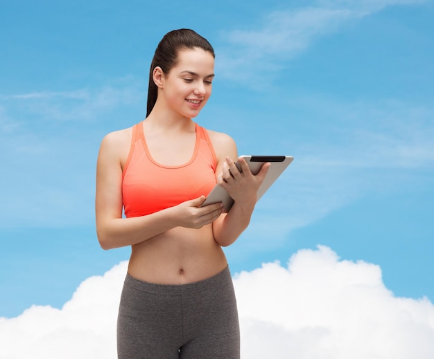 sport, beweging, technologie, internet en gezondheidszorg - sportieve vrouw met tablet pc-computer
