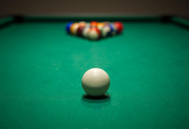 Sport billiard balls set arranged in shape of triangle on green billiard table in pub