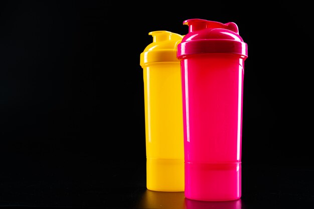 Sport bottles for drink on black surface