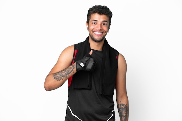 Спортивный бразильский мужчина с полотенцем, изолированным на белом фоне, жестом показывает палец вверх