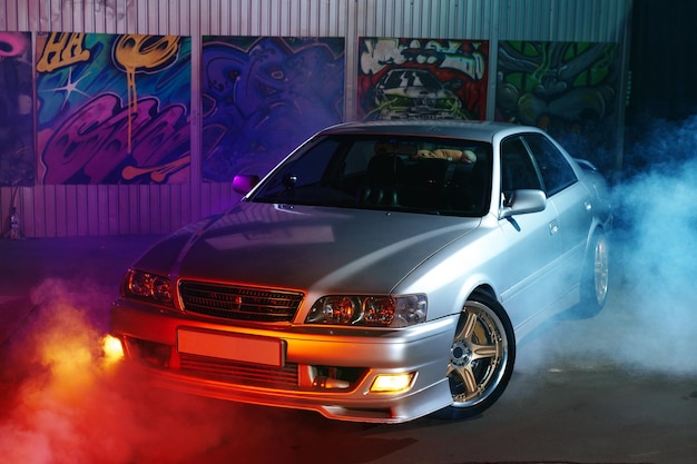 sport car at the night city street in neon light with smoke