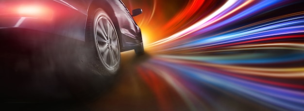 Sport car wheel drifting and smok on colorful lighting background