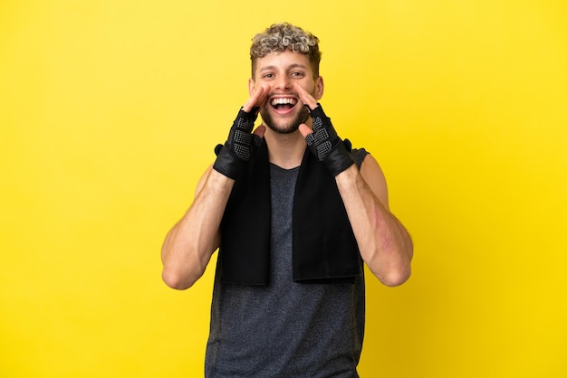 Sport caucasian man isolated on yellow background shouting and announcing something