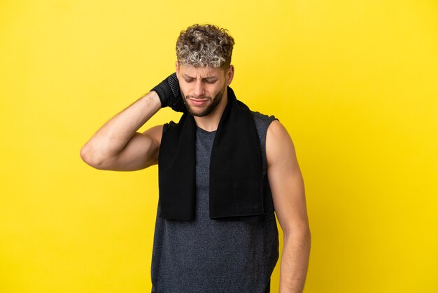 Sport caucasian man isolated on yellow background with neckache