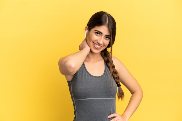 Sport caucasian woman isolated on yellow background laughing