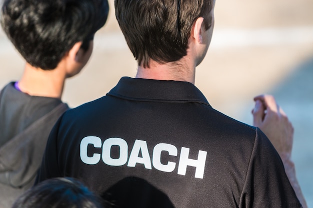 Sport coach in black shirt with the word Coach written on