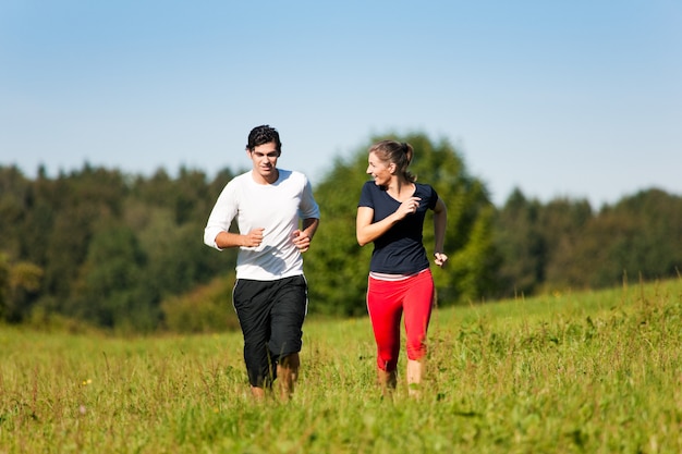 sport couple jogging at meadow