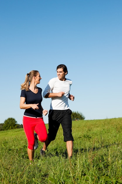 sport couple jogging at meadow