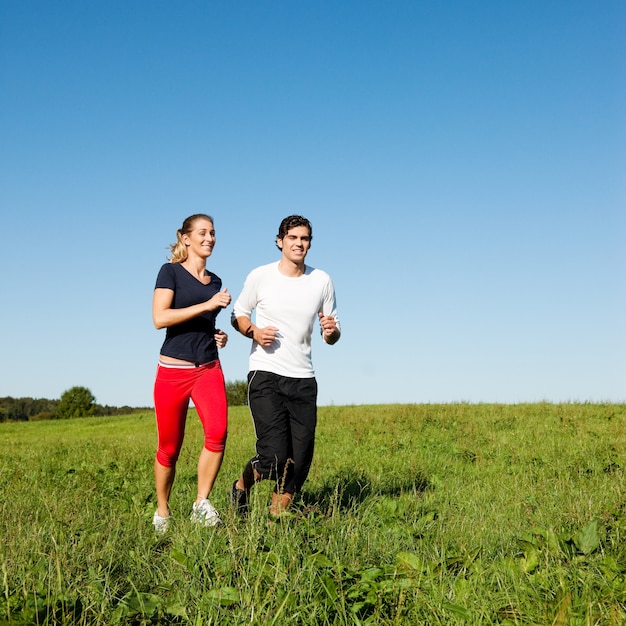 Coppia sportiva jogging a prato