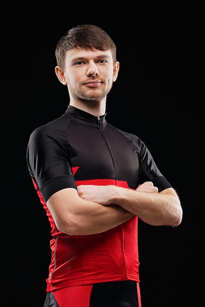 Sport. Cyclist in training clothes on black background.