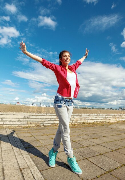 sport, dancing and urban culture concept - beautiful dancing girl in movement with raised hands