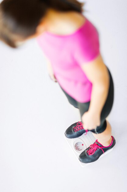 스포츠, 다이어트 및 체중 감량 개념 - 저울에 서 있는 여자 다리